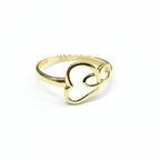 Gold ring with heart design on a gray background