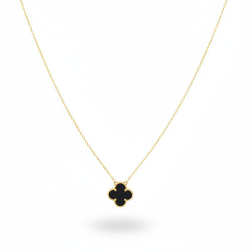 Necklace with a clover-shaped pendant on a beige jewelry display.