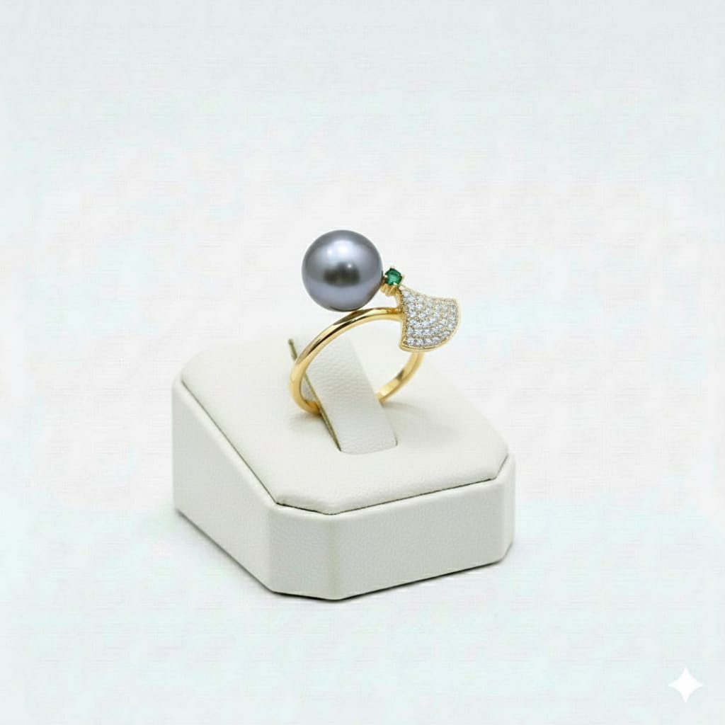 Gold ring with a large gray pearl on a white stand against a light gray background